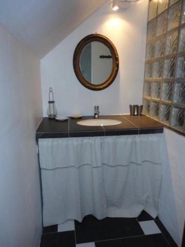 une salle de bain avec un lavabo et un miroir dans l'établissement Le Bois Guillaume, à Domfront-en-Champagne