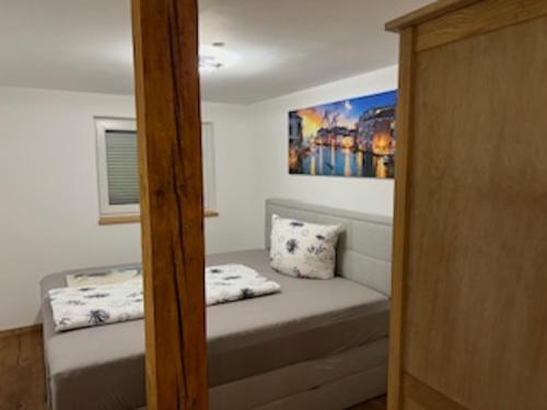 a small bedroom with a bed and a painting on the wall at Ferienhaus bis 6 Personen in Weißensberg