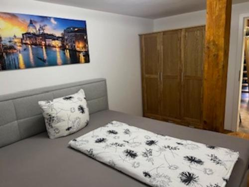a bed with a pillow and a painting on the wall at Ferienhaus bis 6 Personen in Weißensberg