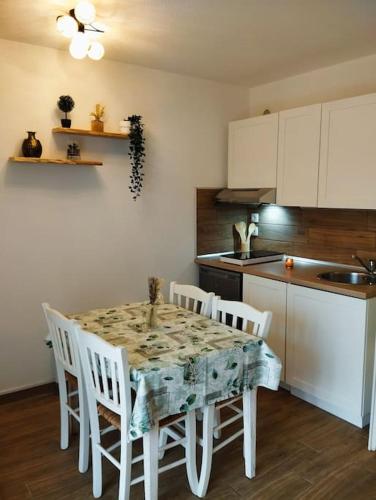 une cuisine avec une table et des chaises et une cuisine avec un comptoir dans l'établissement Appt 4-5 pers au Verdon-sur-Mer dans résidence de tourisme 3 étoiles, au Le Verdon-sur-Mer