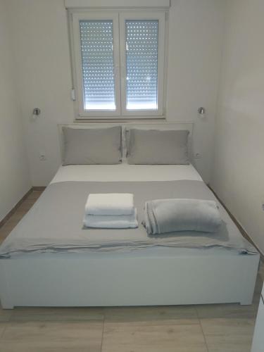 a large white bed in a room with two pillows at Apartman Ariana in Gradac