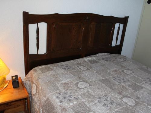 un lit avec une tête de lit en bois à côté d'une table dans l'établissement Appt cosy 4 pers, proche plage, parking - FR-1-229-769, à Gruissan