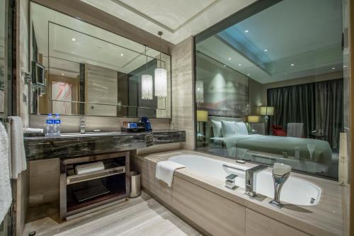 bagno con lavandino e grande specchio di Wanda Realm Wuhan a Wuhan