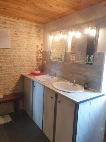 a bathroom with two sinks and a mirror at La ferme de Tart in Verdonnet