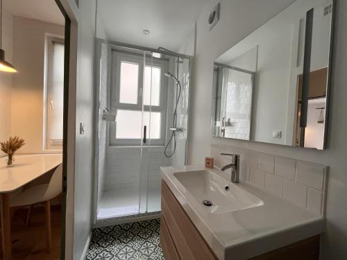 une salle de bain blanche avec une douche et un lavabo dans l'établissement Anna in Paris, à Paris