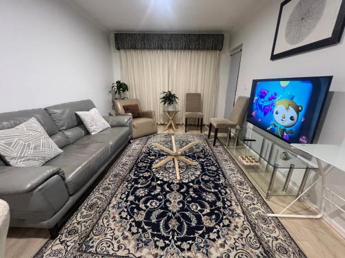 a living room with a couch and a flat screen tv at ADELAIDE CBD APARTMENT - 3BR, 2BATH & CARPARK in Adelaide