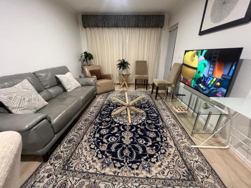 a living room with a couch and a tv at ADELAIDE CBD APARTMENT - 3BR, 2BATH & CARPARK in Adelaide