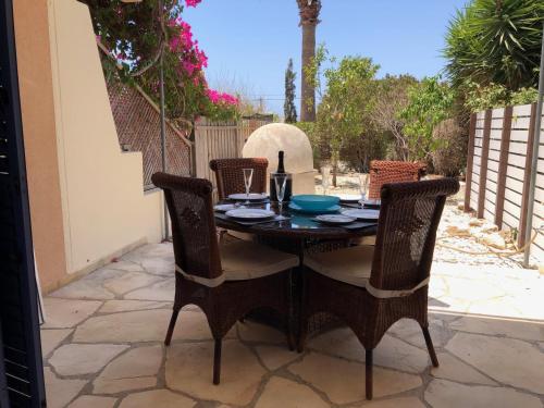 ein Holztisch und Stühle auf einer Terrasse in der Unterkunft Regina Gardens - Modern 2 bed maisonette in Paphos City