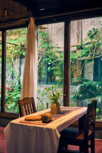 a table with a white table cloth and a vase on it at The Hermit Sapa Homestay in Sa Pả