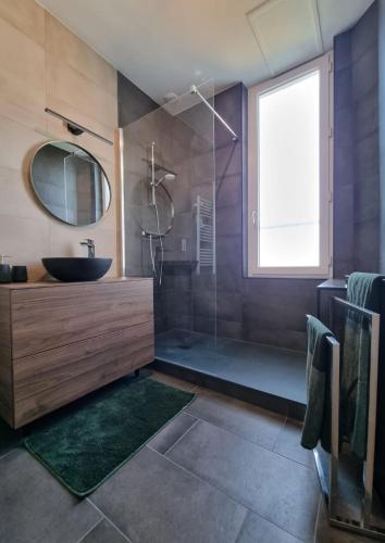 une salle de bain avec un lavabo et un miroir dans l'établissement LAGUNE ÉLÉGANTE CENTRE spacieux et à 5 min de la plage, à Dinard