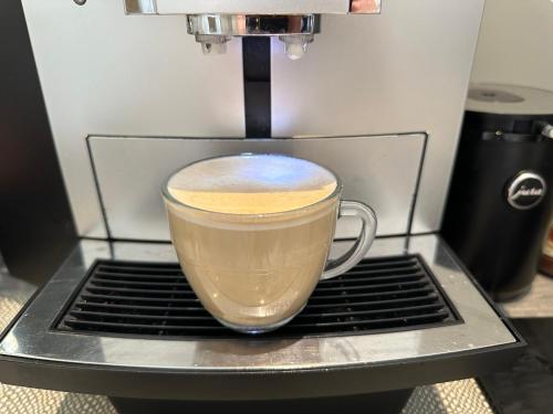 a cup of coffee is being made in a espresso machine at Number One Hundred Bed And Breakfast in Cardiff