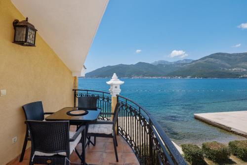a balcony with a table and chairs and a view of the water at Apartment Villa Marija in Tivat