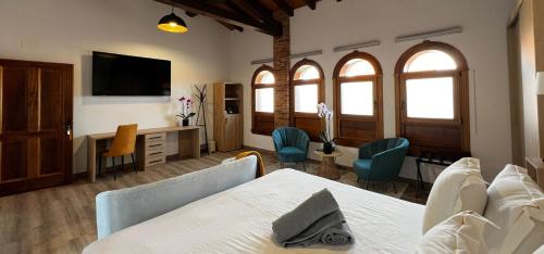 a bedroom with a bed and a desk with chairs at Hospedium Hotel Rural Abadía de Yuste in Cuacos de Yuste