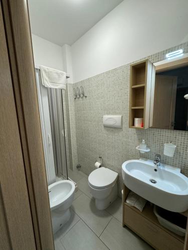 a bathroom with a white toilet and a sink at Casa Vacanze Il Borghetto in Marzamemi