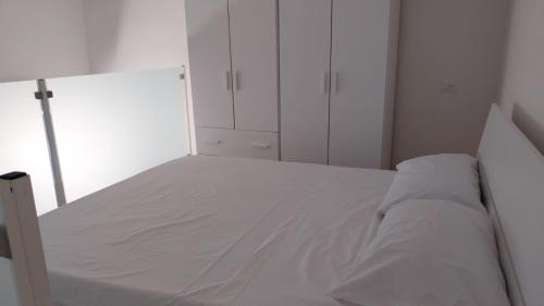 a white bedroom with a bed with white cabinets at Proxima in Nola