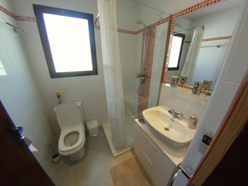 een badkamer met een toilet, een wastafel en een spiegel bij CASA CHOULOU Moraira in Moraira