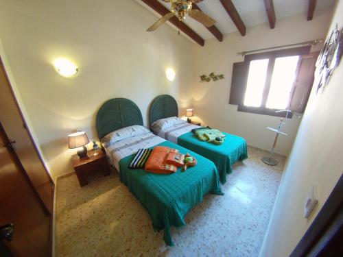 een slaapkamer met twee bedden en een raam bij CASA CHOULOU Moraira in Moraira