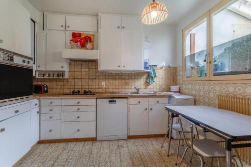 une cuisine avec des armoires blanches et une table dans l'établissement Villa de famille Maragre, au calme, à Sainte-Marie-la-Mer