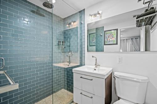Un baño con inodoro y lavabo y azulejos azules. en villa venezia bb, en Miami Beach