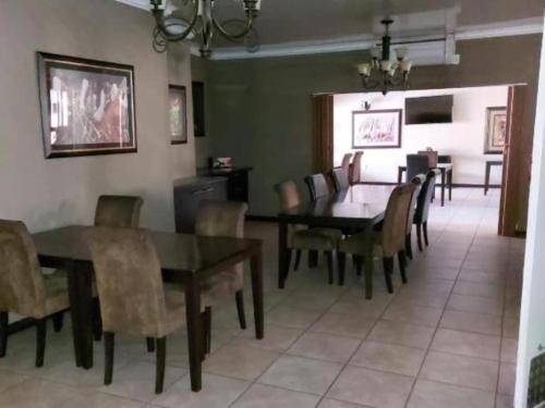a dining room with a table and chairs at Ikhutse Manor Guesthouse in Mahikeng