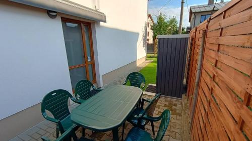 a green table and chairs on a patio at Apartmán Na Kvetnej - vlastná záhrada, parkovanie in Poprad