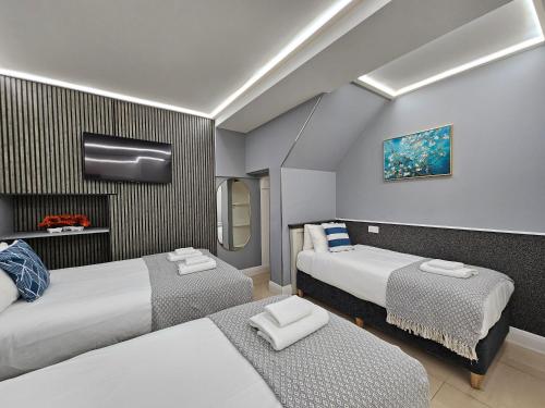 a hotel room with two beds and a tv at London Stay Apartments in London