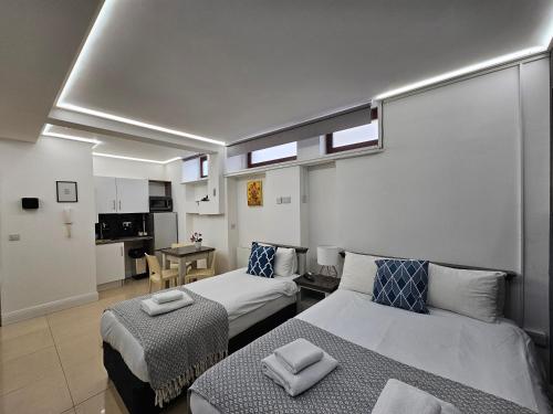 a hotel room with two beds and a kitchen at London Stay Apartments in London