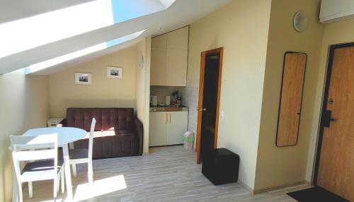 ein Zimmer mit Tisch und Stühlen und eine Küche in der Unterkunft Butukas Nidai in Nida