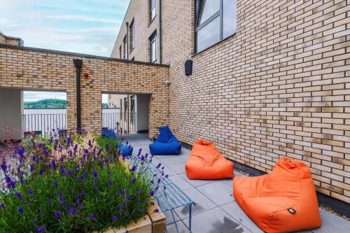 three orange and blue bean bags sitting next to a brick building at Hilltop Serviced Apartments - Sheffield in Sheffield