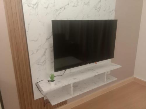 a flat screen tv sitting on a white shelf at Youth City Nilai in Nilai