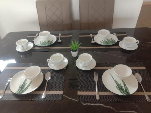 a table with white plates and silverware on it at Youth City Nilai in Nilai