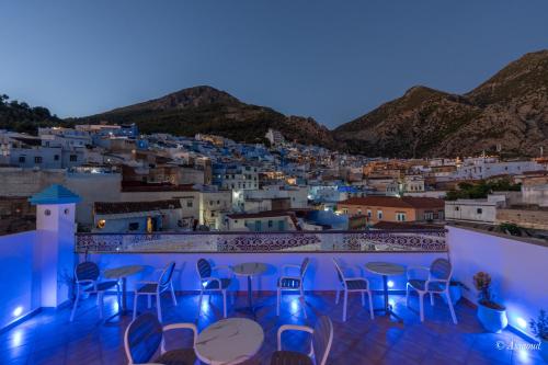 a view of a town at night with tables and chairs at Dar Kisania in Chefchaouene