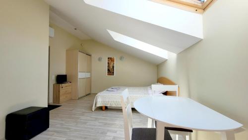 ein kleines Zimmer mit einem Tisch und einem Bett in der Unterkunft Butukas Nidai in Nida