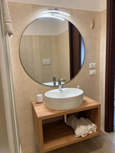 a bathroom with a sink and a large mirror at B&B Zio Cici in Minervino di Lecce