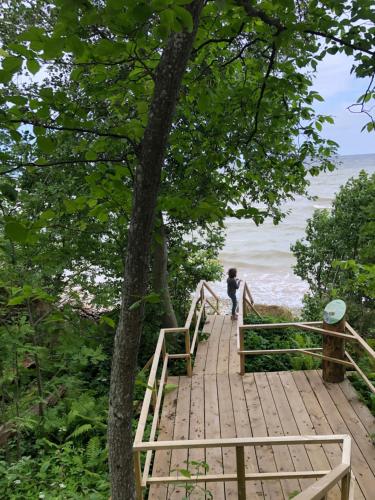 a person standing on a wooden bridge near the beach at Ontika Manor Unique Apartment in Ontika Asundus