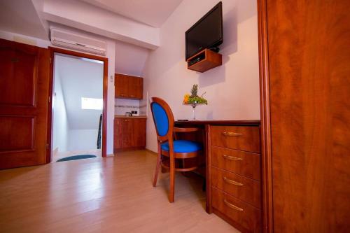 a kitchen with a desk and a blue chair in a room at Apartments Villa Cardo in Mali Ston