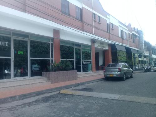 a car parked in a parking lot in front of a building at Hotel Frutas del Lago in Caucasia