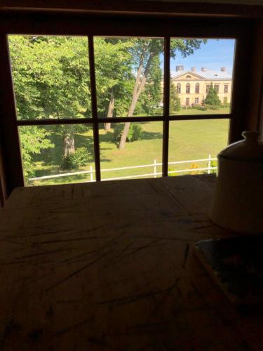 a window in a bedroom with a view of a house at Ontika Manor Unique Apartment in Ontika Asundus