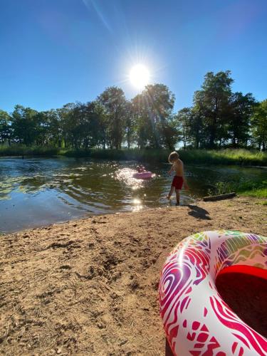 a young boy standing on a beach next to a body of water at Ontika Manor Unique Apartment in Ontika Asundus