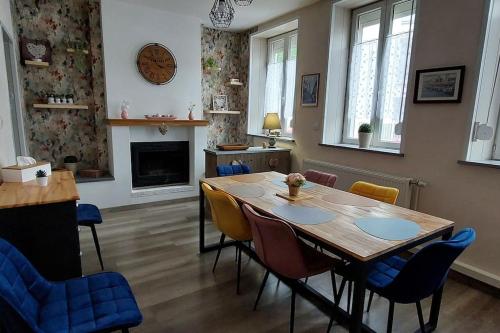 une salle à manger avec une table et des chaises et une cheminée dans l'établissement Aux Pierres d'Opale, maison 3 ch, 4 à 6 pers, à Boulogne-sur-Mer
