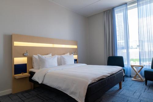 a hotel room with a bed and a large window at Best Western Plus Park City Malmö in Malmö