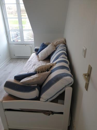 un lit avec des oreillers dessus dans une chambre dans l'établissement bel appartement 4 personnes, à Port-en-Bessin-Huppain