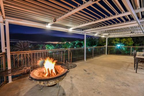 a fire pit on a patio with a table and chairs at Blue Rain Guest House in Bloemfontein