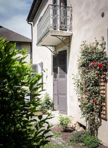 - un bâtiment avec un balcon, une porte et des fleurs dans l'établissement Venez Chez Vous La Maison des Balmettes, à Annecy