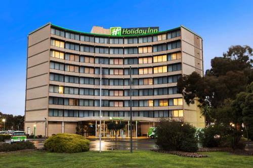 a building with a sign on top of it at Holiday Inn Melbourne Airport by IHG in Melbourne