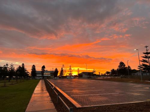 Una cancha de tenis con una puesta de sol al fondo en Beach side holiday unit, en Port Adelaide