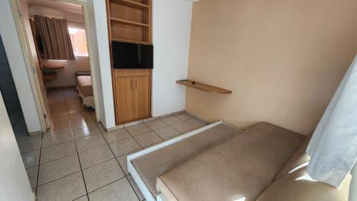 a room with a couch and a tv in it at diRoma Fiori - Apartamentos JN in Caldas Novas