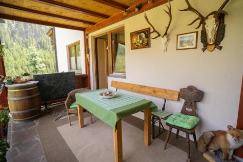 a dining room with a table and a cross on the wall at Ferienwohnung Alpenblick in Navis