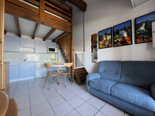 un salon avec un canapé bleu et une cuisine dans l'établissement Charmant pavillon T2, climatisé, 4 pers, proche plage et commerces, parking privé - FR-1-81-574, à Port-Leucate