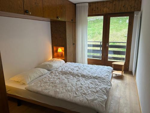 a bedroom with a large bed and a window at Ramuge COSY & MOUNTAINS apartments in Veysonnaz